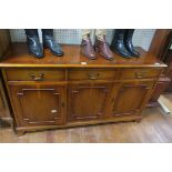 A YEW WOOD SIDE CABINET of rectangular outline the shaped top above two frieze drawers and