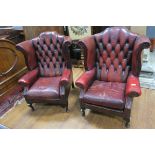 A PAIR OF HIDE UPHOLSTERED WINGED LIBRARY CHAIRS each with deep buttoned upholstered back and loose