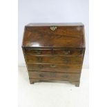 A GEORGIAN MAHOGANY BUREAU the rectangular top above a hinged writing slope containing pigeon holes