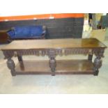 Elizabethan style carved oak dresser base with two drawers, ring handles, bulbous supports, board