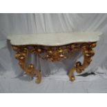 Italian carved gilt wood console table with white, figured marble top, C scroll and swag decoration.