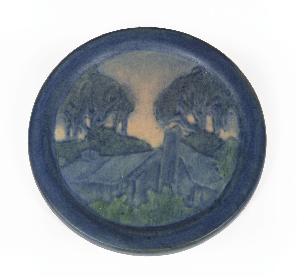 Newcomb College Art Pottery Plaque , decorated with low relief-carved cabin and trees design,