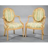 Pair Louis XVI-Style Giltwood Fauteuils , oval back, padded arms, floral-blocked seat rail, fluted