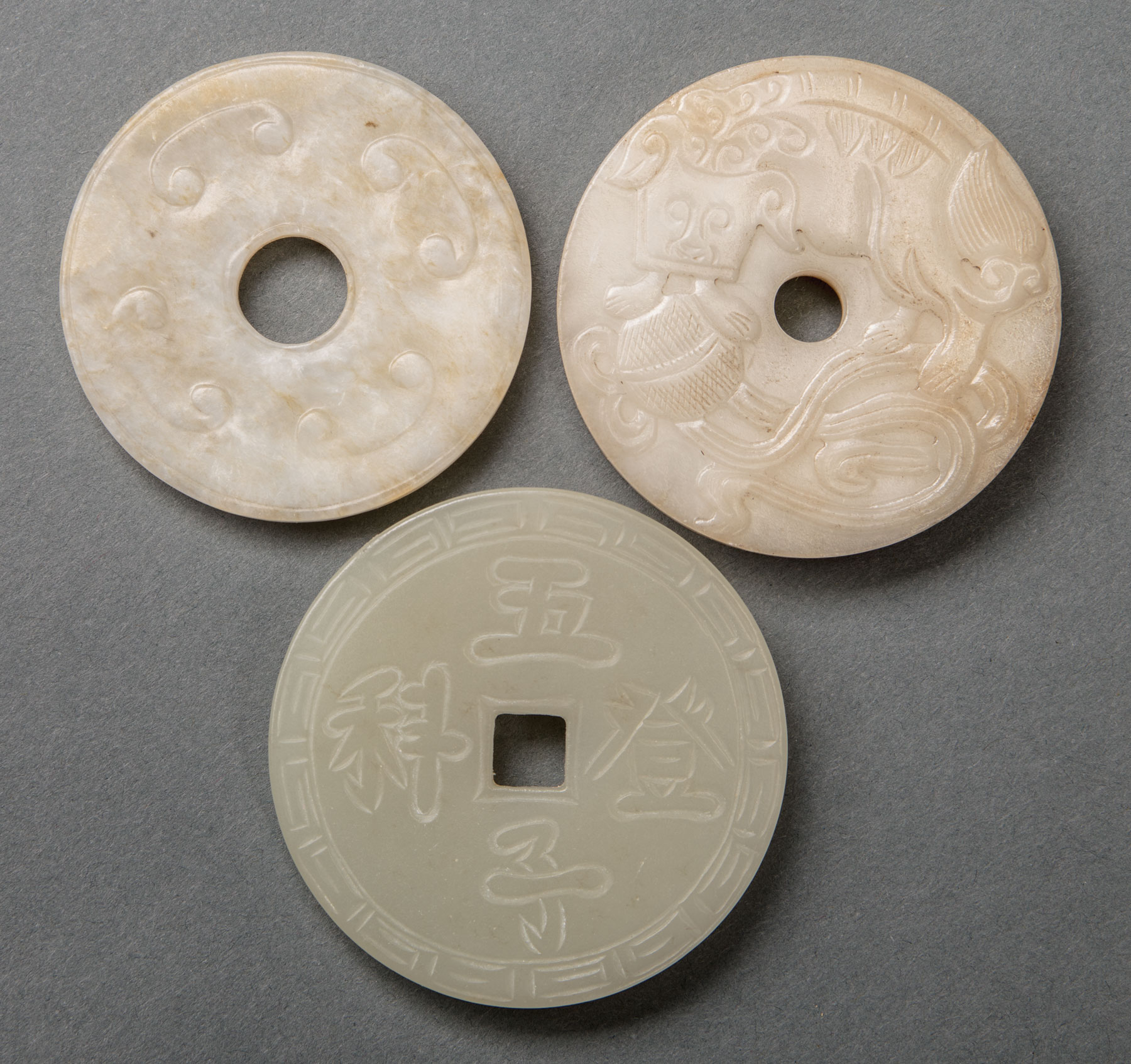 Three Archaistic Chinese Jade Bi Disks , incl. 2 of creamy white and russet stone, dia. 2 1/4 in.