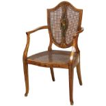 Edwardian Painted Satinwood Armchair , c. 1900, shield-back centered by a maiden reserve, caned back