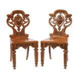 Pair of English Carved Oak Hall Chairs, 19th c., shaped crest rail, cabochon centered scrolled back,