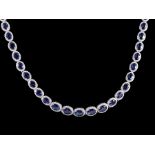 14 kt. White Gold, Sapphire and Diamond Necklace, 45 graduated prong set oval mixed cut blue