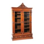 American Renaissance Carved Walnut and Burl Bookcase, late 19th c., surmounted by a palmette