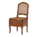 French Provincial Carved Walnut Commode Chair, 19th c., floral carved crest, caned back, hinged cane