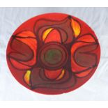 A Poole Pottery 'Delphis' pattern dish, decorated in shades of red, brown and orange, 27cm diameter