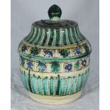 A Middle-Eastern tin-glazed earthenware jar and cover, decorated in green, yellow and blue geometric