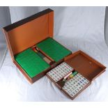 Two assorted cased Mahjong sets, including dice, tiles and counters, housed in fitted, simulated