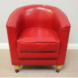 A modern red leather upholstered tub chair, raised on turned supports to castors