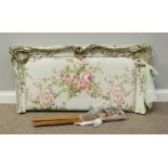 An ornately carved and distressed single bedhead, with padded, floral fabric upholstery, 111cm wide