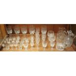 A shelf of assorted crystal glassware including five large twist-stemmed wine glasses, sherry