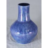 A Ruskin pottery vase of globular form with flared neck, mottled blue iridescent glaze, impressed