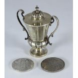 A small silver two-handled trophy cup and cover, Birmingham, 1959, together with a Quenn Victoria