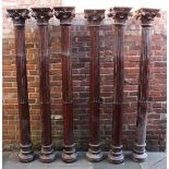 Six large stained wooden half-fluted colums with Composite Capitals, approx. 208cm tall including