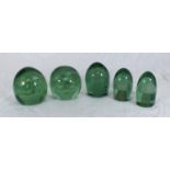 Five various 19th century green glass dumpy paperweights with flower and mushroom bubble inclusions,