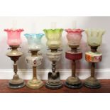 Five assorted oil lamps, all with glass shades and four with chimneys etc.