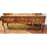 An 18th century oak dresser base, with three freeze drawers, original pierced brass handles and