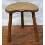 A Robert 'Mouseman' Thompson of Kilburn oak three-legged calf stool, the dished, kidney shaped