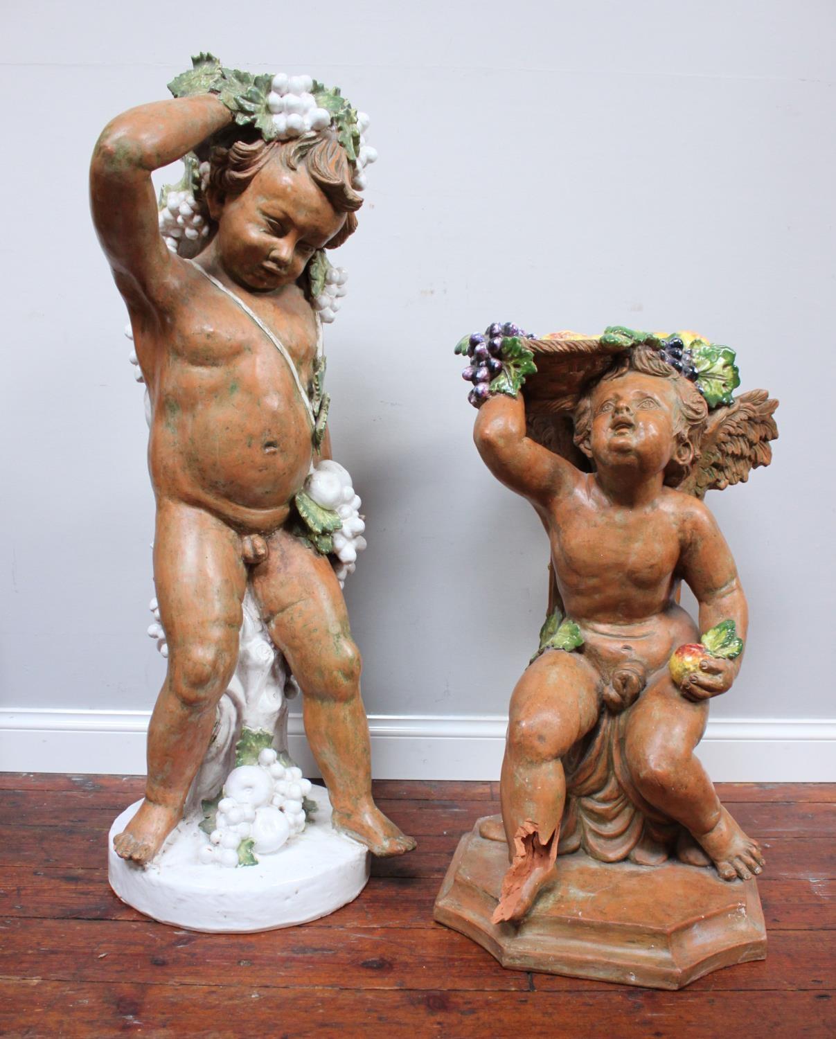 Two matched early 20th century painted terracotta garden ornaments one modelled as a cherub, the