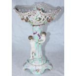 A German porcelain centrepiece with pierced and floral encrusted bowl supported by two putti, on