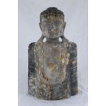 An antique carved and painted half-length wooden sculpture of a Buddha, with traces of original