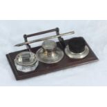 A George V wooden ink stand with silver-mounted nib wipe, capstan inkwell, stamp wetter-roller and