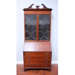 An Edwardian stained mahogany bureau bookcase in the Sheraton style with broken swan-neck pediment