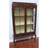 A stained mahogany two-door glazed display cabinet with dentil moulding, 3 shelves above a pair of