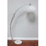 An Art Deco chromium plated arched floor lamp with opaque glass shade, on circular white marble