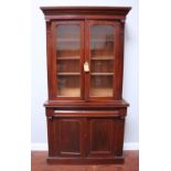 A Victorian mahogany bookcase, the cornice above two glazed doors enclosing three adjustable