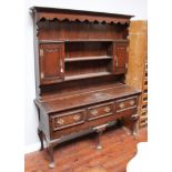 A good 18th century and later stained oak dresser, the raised back with shaped frieze and sides,
