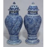 A pair of Kangxi blue and white baluster vases each with spiral-fluted midsection decorated in deep,