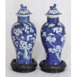 A pair of Chinese porcelain vases and covers, of slender baluster form, decorated with prunus