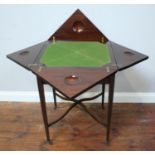 An Edwardian inlaid mahogany envelope card table with 'X' stretcher and raised on castors (as found)