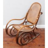 A Thonet design stained beach bentwood rocking chair with caned back and seat panel