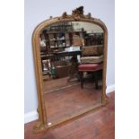 A 19th century gold-painted oval-mantel mirror with arched top, scrolling crest and beaded frame,