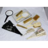 A 1920s ivory dressing table set of four brushes and a hand-held mirror all with monogram 'MA',