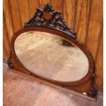 An Edwardian mahogany and marquetry oval over-mantel mirror, with pierced fret-carved pediment,