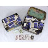 Two tins of assorted cigarette cards, predominantly arranged into sets and stored in Churchman's '