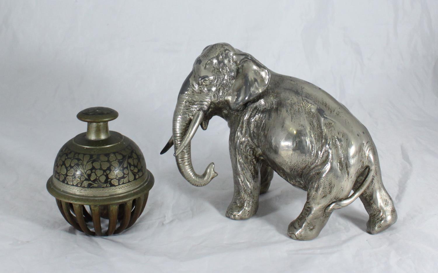 An Indian cast bronze elephant claw bell with engraved foliate decoration, together with a silver-