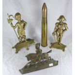 Three various brass military figural doorstops, together with a 40mm brass round