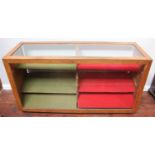 An oak haberdashery/shop display counter, the glass top and glazed front enclosing two-section