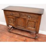 A small oak sideboard, the two carved frieze drawers above two carved panelled cupboard doors