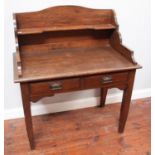 An early 20th century stained oak dressing table, with three-quarter shaped gallery, two frieze