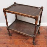 An oak two-tier trolley, with carved decoration, raised on turned supports to castors, 69cm long