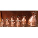 Ten graduated copper Haystack rum measures including 1 x gallon, 1 x quart, 2 x pint, 3 x 1/2